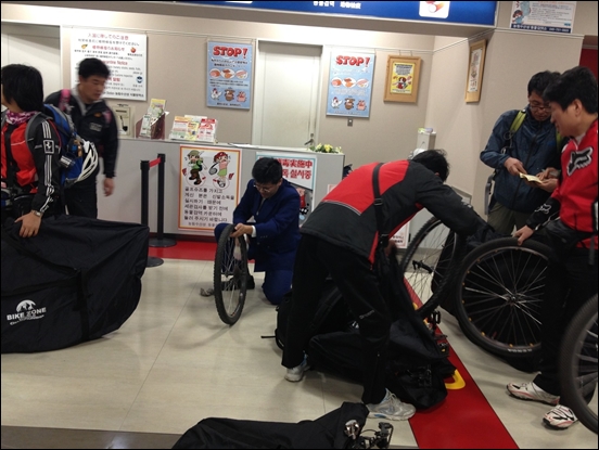 일본 세관 직원이 자전거 바퀴를 모두 닦고 있다