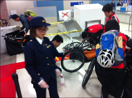 일본 세관에서 분리된 자전거를 조립하고 바퀴를 닦고 있다