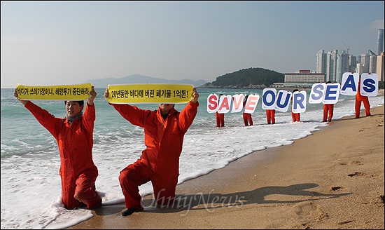 환경운동연합이 7일 오전 부산 해운대에서 육상폐기물의 해양배출 중단을 촉구하는 행사를 열고있다.