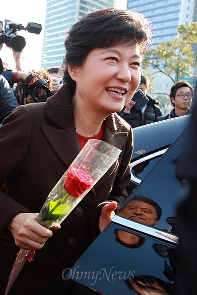 박근혜 새누리당 대선후보가 9일 오후 부산 해운대구 벡스코에서 열리는 'G-STAR 2012 국제게임전시회 지스타'를 방문하고 나오며, 한 60대 남성이 전달한 장미꽃 한송이를 들고 있다.