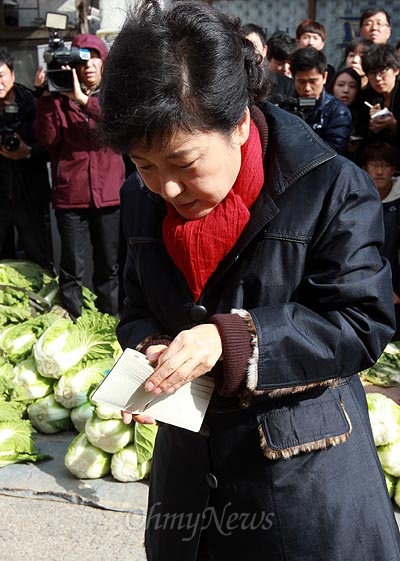 박근혜 새누리당 대선후보가 12일 오후 전북 익산 금마시장을 방문해 미나리를 구입한 뒤 지갑에서 지폐를 꺼내고 있다.