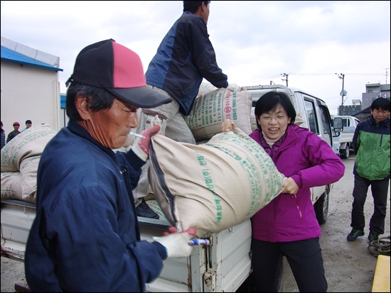 통합진보당 이정희 대선후보가 충남 예산의 추곡수매현장에서 한 농민과 함께 조곡용 포대를 차에서 내리고 있다.