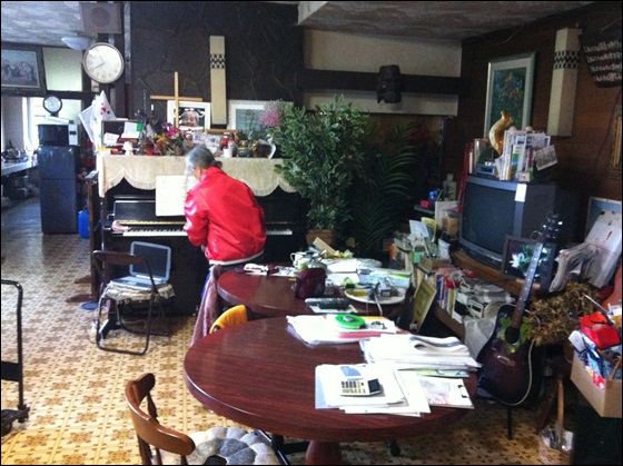 피아노와 기타가 놓인 식당/ 빨간 옷 입은 이가 유스호스텔을 운영하는 82세 할머니