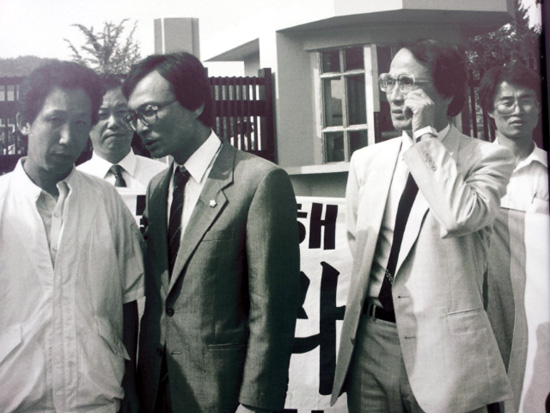  민청련 김근태 의장(맨 왼쪽)이 1988년 6월 30일 김천교도소에 출소한 날 아침 후배 이해찬 의원, 장영달 전 의원과 대화를 나누고 있다. 뒤쪽 오른쪽 현수막을 들고 있는 이가 필자다.