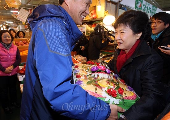박근혜 새누리당 대선후보가 13일 오후 대전광역시 유성구 노은농수산물도매시장에서 한 상인으로부터 과일을 선물받고 있다.