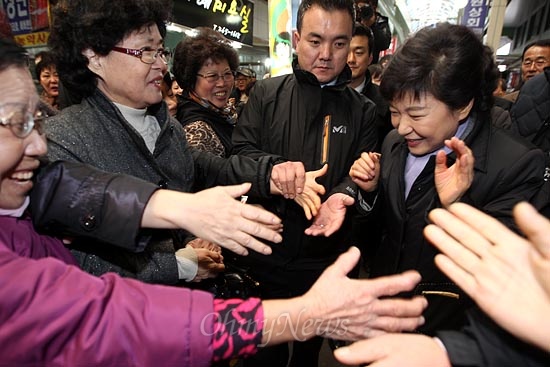 박근혜 새누리당 대선후보가 14일 오후 충북 청주시 육거리종합시장을 방문하자 시민들 여럿이 악수를 하자며 손을 내밀고 있다.