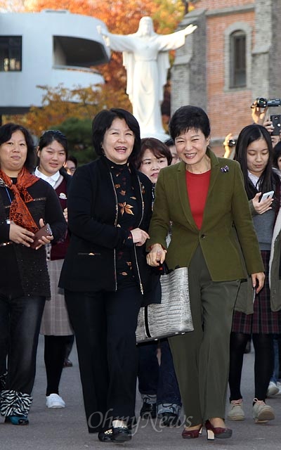 박근혜 새누리당 대선후보가 15일 오후 모교인 서울 용산구 성심여고를 방문한 뒤 동문들과 함께 교정을 나오고 있다.