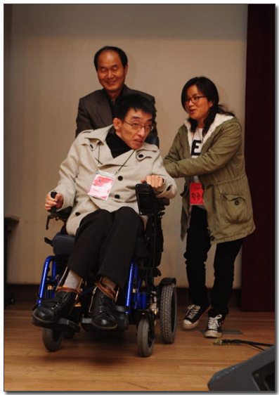 류홍준 한국뇌병변장애인인원협회 회장 류홍준 회장을  상임이사인 이수호 서울시 교육감 후보와 활동가가 무대에 오르도록 도와주고 있다.