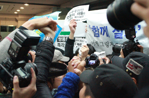 박근혜 후보가 토크콘서트 행사장에 입장한 뒤 <노동자 연대 대학생 그룹> 소속 학생들과 쌍용차 해고노동자들이 사복경찰에 밀려나며 구호를 외치고 있다.