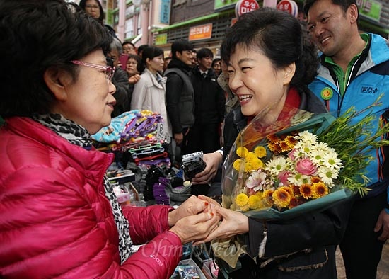 박근혜 새누리당 대선후보가 16일 오후 경남 창원 가응정시장에서 한 속옷매장 주인으로부터 꽃다발을 받고 있다.