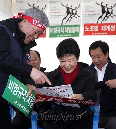 박근혜 당시 새누리당 대선후보가 2012년 11월 17일 오후 서울 여의도 문화마당에서 열린 한국노총 전국노동자대회에 참석해 최인백 사무처장에게 손피켓과 행사 자료를 받고 있다.