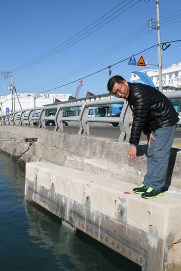 삼천포유람선협회에 근무하는 최동환 씨가 플랩게이트 시설물 일부가 뜯겨 나갔음을 설명하고 있다.