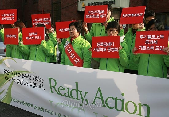 청소노동자 출신 김순자 후보가 21일 오전 서울 종로구 청운동사무소에서 대선출마선언 기자회견을 열고 있는 가운데 대선공약이 써 있는 손피켓을 지지자들이 들고 있다.