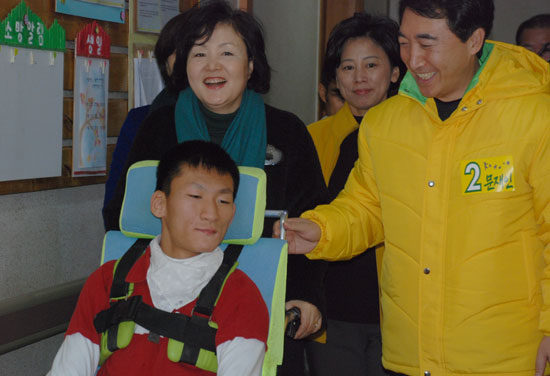 소망의 집에 도착한 문재인 민주통합당 대선후보 부인 김정숙씨가 뇌 병변을 앓고 있는 주호씨의 휠체어를 이끌고 식당으로 향하고 있다.
