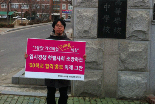 박고형준 활동가가 학교 앞에서 특정학교 합격을 홍보하는 현수막 제거를 요구하는 일인 시위를 하고 있다.
