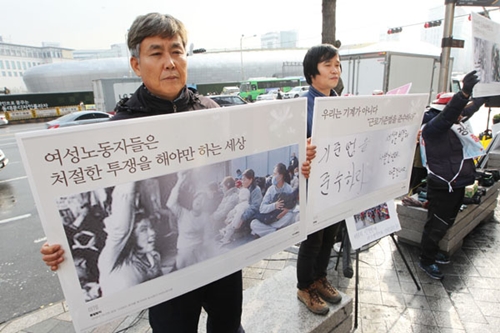 28일 오후 서울 동대문 두산타워 앞에서 민주노총 소속 정리해고 사업장 노동자들과 70년대 노동운동가가 해고 철회를 호소하며 선전활동을 하고 있다. 