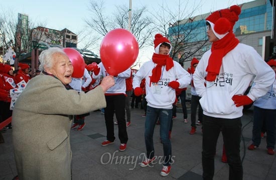 빨간 풍선을 든 한 할머니가  29일 오후 박근혜 새누리당 대선후보 서포터스 '빨간운동화'의 인천 부평역 광장 유세를 바라보고 있다.