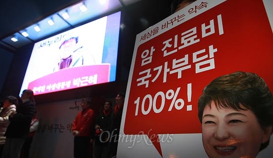 박근혜 새누리당 당시 대선후보가 지난해 12월 29일 오후 인천 부평역광장 유세에서 연설을 하는 가운데 '암 진료비 국가부담 100%!'라고 쓰인 손피켓이 놓여 있다.