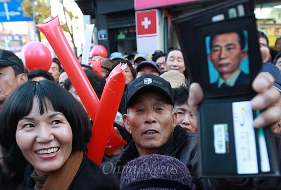 30일 오후 부산 서구 충무시장에서 열린 박근혜 새누리당 대선후보 유세에서 한 지지자가 지갑 속에 있는 박정희 전 대통령의 초상화를 들어보이고 있다.
