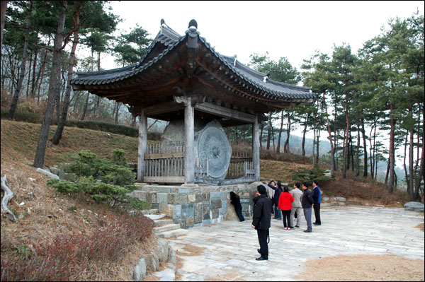 석경 여행자들이 석경 아래 바위에 머리를 대고 기를 받고 있다.