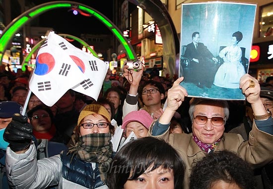 박근혜 새누리당 대선후보가 30일 오후 부산 중구 피프광장에서 유세를 펼치자, 한 지지자가 박정희 전 대통령과 육영수씨의 사진을 들어보이고 있다.