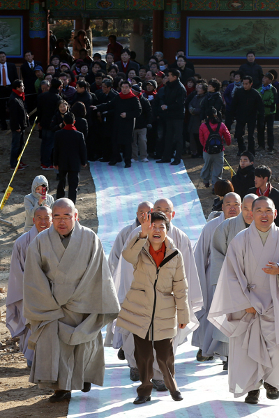 새누리당 박근혜 대선후보가 1일 오전 부산 금정구 청룡동 범어사를 방문, 스님들과 함께 대웅전으로 향하며 신도들에게 손을 흔들고 있다.
