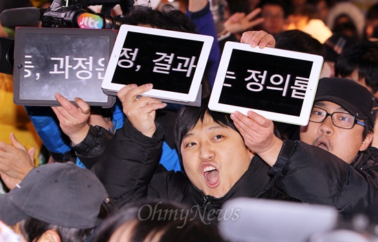 5일 저녁 서울 마포구 홍익대 인근에서 문재인 민주통합당 대선후보가 거리유세를 펼치자, 한 지지자가 문 후보의 카피 "기회는 평등하게, 과정은 공정하게, 결과는 정의롭게"를 태블릿 PC에 띄워 연호하고 있다. 