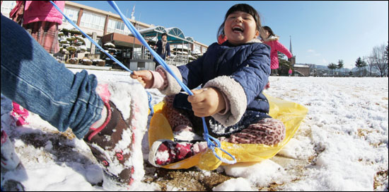 6일 경남 함양군 지곡면 지곡초등학교 운동장에서 선생님과 어린이들이 마대 포대를 이용해 썰매를 타며 즐거운 시간을 보내고 있다.
