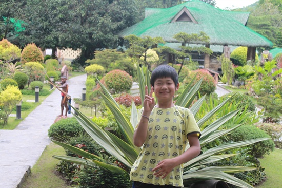 필리핀 가족여행 푸닝온천. 이 원주민 나름 프로다. 큰 아이가 사진을 찍자 기꺼이 배경이 되어 준다.