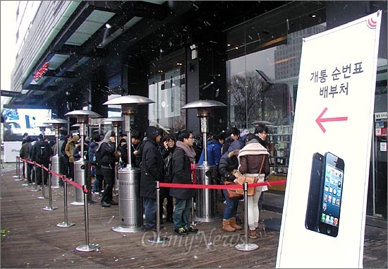 아이폰5 개통이 시작된 지난해 12월 7일 오전 8시 KT 광화문 사옥 올레스퀘어 앞에 대기자 100여 명이 줄을 서 있다.