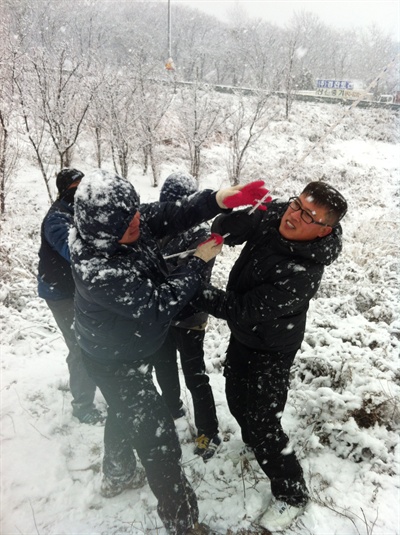  쌍용자동차 철탑 고공농성자들을 위해 땅에서 해고 노동자들이 밧줄에 물품을 묶어 위로 올리고 있다. 