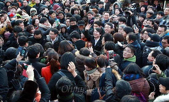 안철수 전 무소속 대선후보가 지난 8일 오후 서울 대학로 마로니에공원에서 문재인 민주통합당 대선후보 지원과 투표참여 활동을 벌이며 시민들에게 둘러싸여 인사를 하고 있다.