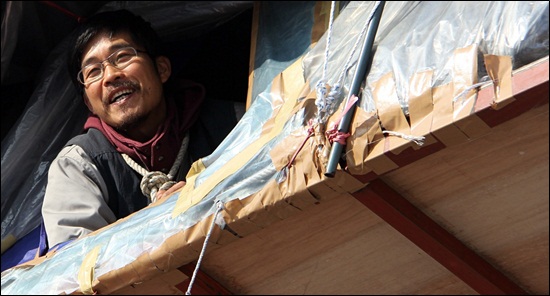 목에 밧줄을 걸고 굴다리 난간에서 농성을 벌이고 있는 홍정인 유성기업지회장(2012년 12월 10일 촬영)