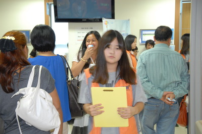한 여학생이 외국인 진료 차트를 들고 의료 담당 직원에게 향하고 있다 