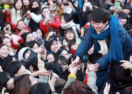  안철수 전 무소속 대선 예비후보가 11일 오후 서울 서대문구 이화여대 앞 번개 모임에서 환호하는 학생과 지지자들의 손을 잡으며 인사를 나누고 있다.