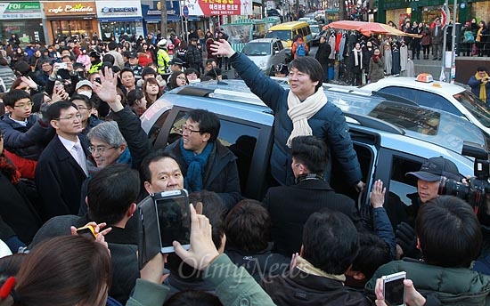 안철수 전 무소속 대선 예비후보가 11일 오후 서울 서대문구 이화여대 앞 번개 모임에서 문재인 민주통합당 대선후보 지원과 투표참여를 독려한 뒤 차량에 올라타 환호하는 학생과 지지자들에게 답례인사를 하고 있다.