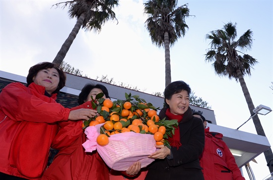 지난 2012년 12월 11일 당시 새누리당 박근혜 대선후보가 제주도 서귀포시 1호광장에서 열린 집중유세에서 지지자들로부터 감귤을 선물 받고 있다.