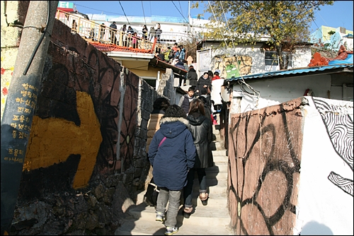 동피랑마을 풍경. 많은 사람들이 담장에 그려진 벽화에 즐거워한다.