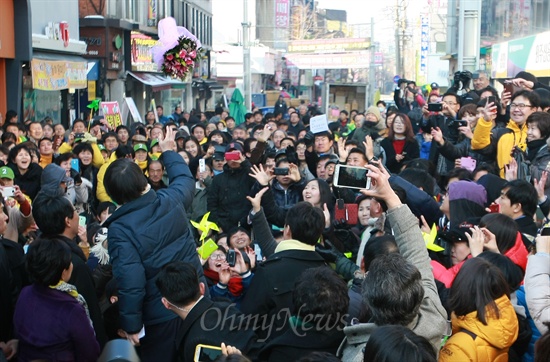 안철수 전 무소속 대선후보가 강금실 전 법무부장관과 함께 12일 오후 강원도 원주시 일산동 중앙시장 문화의거리에서 원주시민들에게 투표 참여를 독려하는 가운데 안 전 후보가 미리 준비한 꽃다발을 시민들을 향해 던지고 있다.