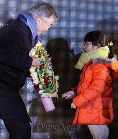 문재인 민주통합당 대선후보가 12일 오후 서산 구터미널 앞 동부시장 유세에서 한 초등학생에게 꽃으로 장식된 기표 모형을 선물받고 있다. 