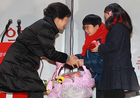 박근혜 새누리당 대선후보가 13일 오후 충북 충주 칠금동 롯데마트 앞 유세에서 쌍둥이 어린이들로부터 당선을 기원하는 '합격사과'를 선물받고 있다.
