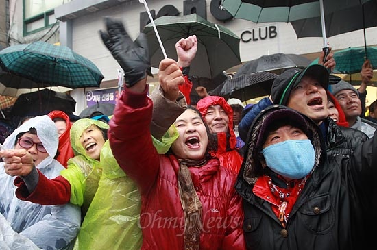 14일 오전 경남 진주 장대동 중앙시장에서 열린 박근혜 새누리당 대선후보 유세에서 비가 내리자, 유권자와 지지자들이 비를 맞으며 박 후보의 연설에 환호하고 있다.
