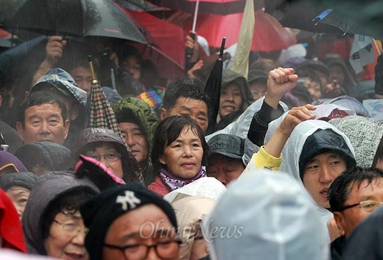 14일 오전 경남 진주 장대동 중앙시장에서 열린 박근혜 새누리당 대선후보 유세에서 비가 내리자, 유권자와 지지자들이 우산을 접고 비를 맞으며 박 후보의 연설을 지켜보고 있다.