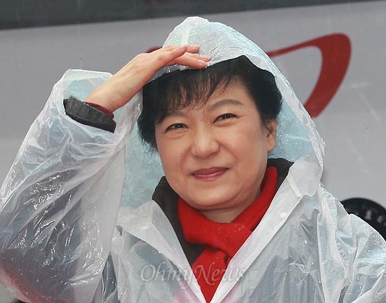 박근혜 새누리당 대선후보가 14일 오전 경남 진주 장대동 중앙시장 유세에서 겨울비가 내리자, 손으로 머리를 가리며 비를 피하고 있다.