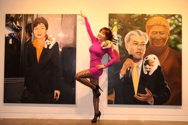 낸시랭이 자신의 개인전 '내정간섭展'의 두 작품 '박근혜'와 '문재인' 앞에서 트레이드마크인 '앙'포즈를 취하고 있다.