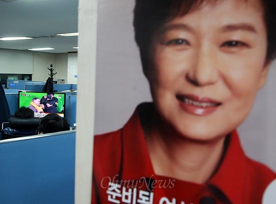 박근혜 새누리당 대선후보 포스터가 붙어 있는 여의도 새누리당사 4층 기자실에서 15일 오후 문재인 민주통합당 대선후보 광화문 집중유세에 안철수 전 대선후보가 깜짝 등장한 장면이 생중계 되고 있다.