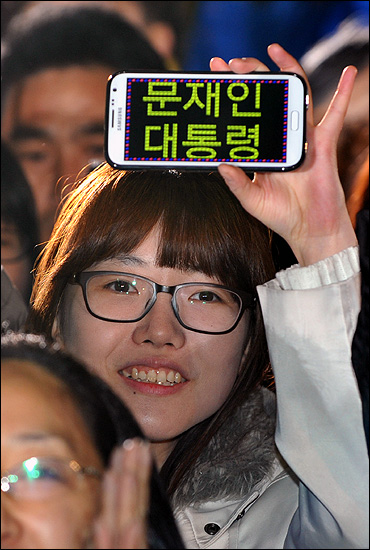 15일 오후 서울 광화문광장에서 열린 '앵콜 광화문 대첩' 현장을 찾은 한 시민이 스마트폰으로 '문재인 대통령' 글짜를 만들어 흔들어 보이고 있다.