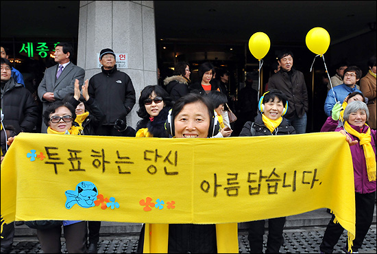 15일 오후 서울 광화문광장에서 열린 '앵콜 광화문 대첩' 현장을 찾은 한 시민이 '투표하는 당신이 아름답습니다' 라고 씌어진 문구를 펼쳐보이고 있다.