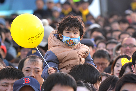15일 오후 서울 광화문광장에서 열린 '앵콜 광화문 대첩' 현장을 찾은 한 어린아이가 '12월19일 투표하세요' 문구가 씌어진 풍선을 들고 있다.