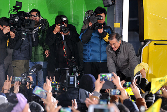 민주통합당 문재인 대선후보가 15일 오후 서울 광화문광장에서 열린 '앵콜 광화문 대첩' 유세차량에 오르며 지지자들과 악수를 하고 있다.